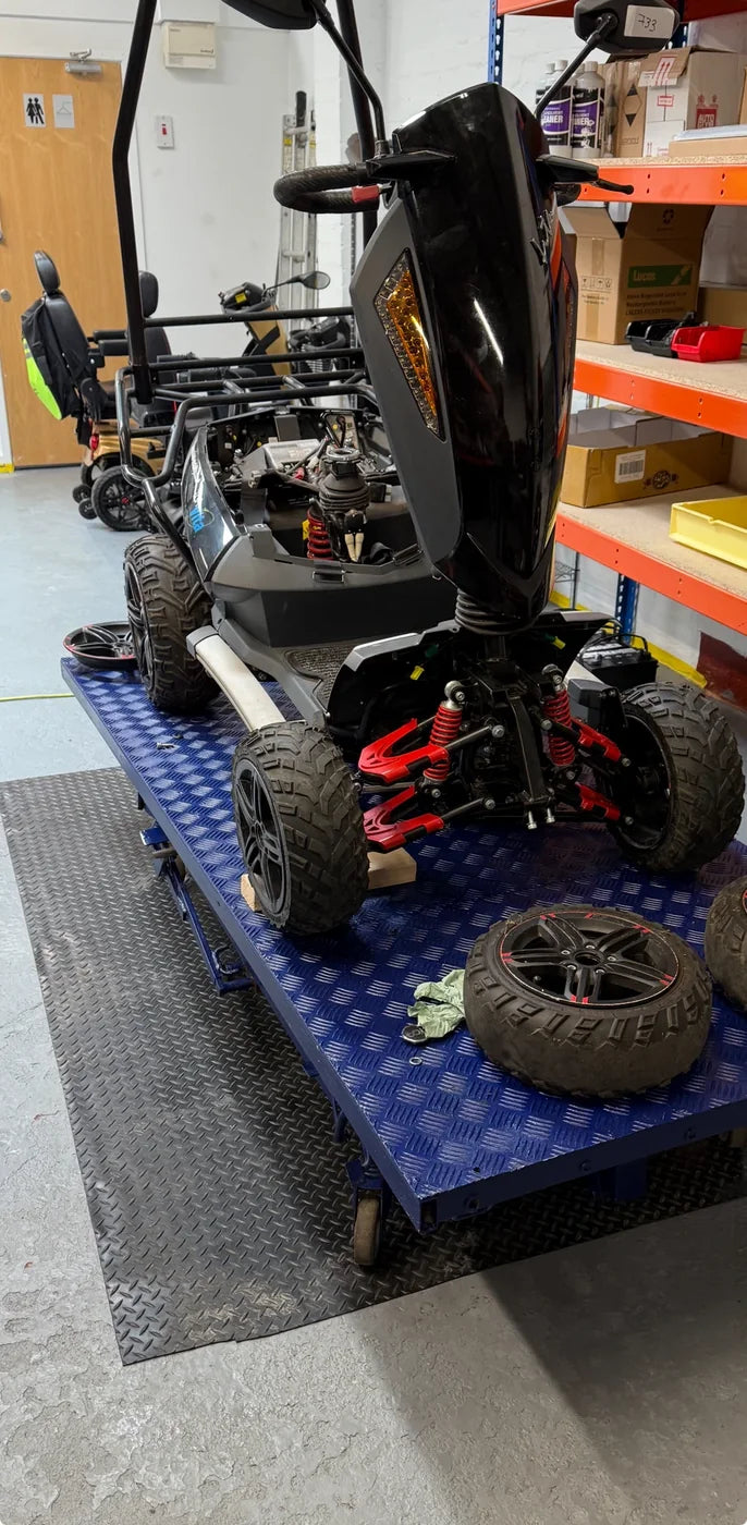 A TGA Vita X mobility scooter raised on the workshop lift at Humber Mobility Centre in Hull during a specialist service and repair